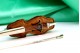 Violoncelo com arco em prata e estrutura em madeira com aplicações.